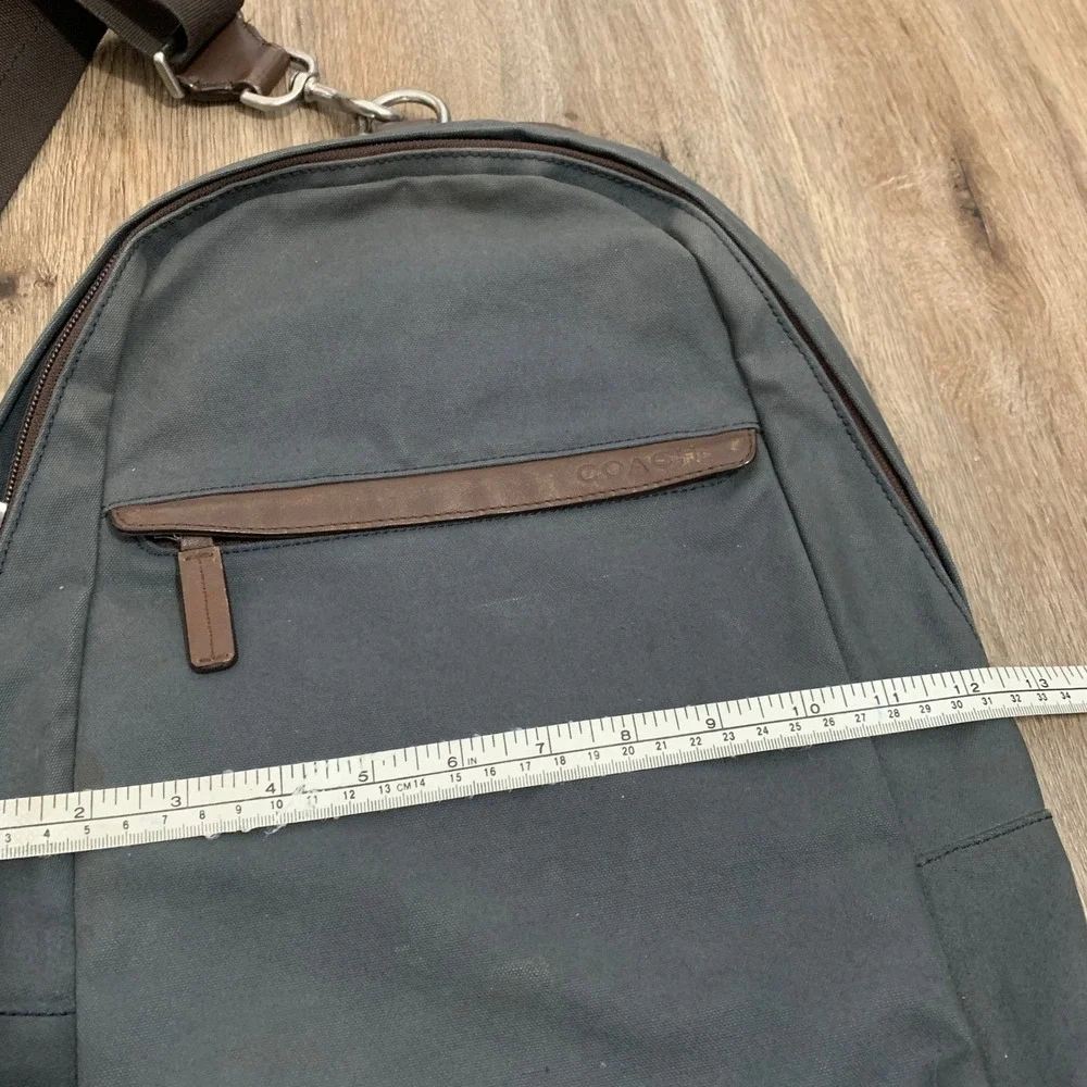 Coach 2013 canvas sling backpack in navy blue w/ brown leather panels - 13x18in‎